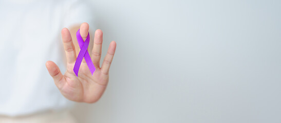 Woman holding purple Ribbon for Violence, Pancreatic, Esophageal, Testicular cancer, Alzheimer, epilepsy, lupus, Sarcoidosis and Fibromyalgia. Awareness month and World cancer day concept