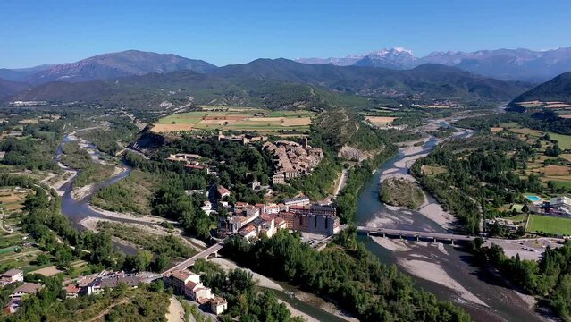 Drone shot, drone video, drone flight, aerial view, flight over the historic castle, castle and church of Ainsa, view of the mountains of the Pyrenees, estuary of Rio Cinca and Ara, province of