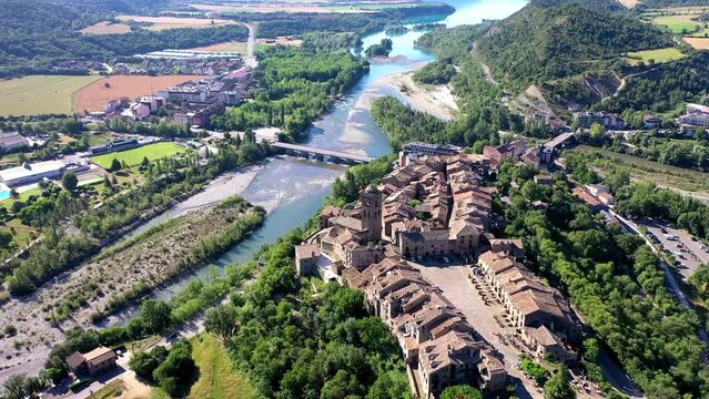 Drone shot, drone video, drone flight, aerial view, flight over the historic castle, castle and church of Ainsa, view of the mountains of the Pyrenees, estuary of Rio Cinca and Ara, province of