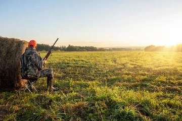 Foto op Canvas hunter with a gun in the field at dawn. Hunter in the nature. Hunting season. © Sergey