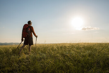 Man hiking at sunset. Travel lifestyle wanderlust adventure concept summer vacations outdoor.