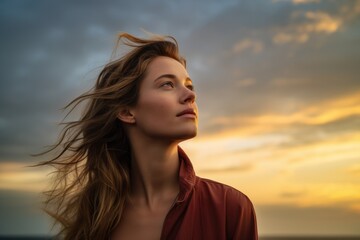 Young woman looking up at the sky at sunset