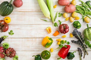 Seasonal vegetables, corn, potatoes, tomatoes, various peppers on a wooden background with a place for text