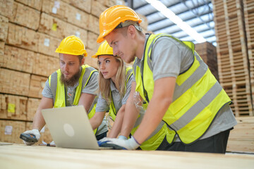 Warehouse worker working at lumber yard in Large Warehouse. Worker are  Inventory check at Storage shelves in lumberyard.