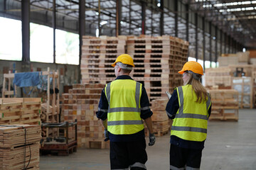 Warehouse worker working at lumber yard in Large Warehouse. Worker are  Inventory check at Storage shelves in lumberyard.