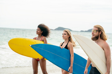 Happy friends with surfboards on the beach