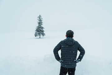 man tourist Visiting in Biei, Traveler in Sweater sightseeing Christmas tree with Snow in winter...