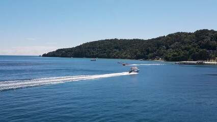 Aerial Flying Over Speed Boats Sailing Past Going Back And Forth From Manukan island. Push Forward Shot