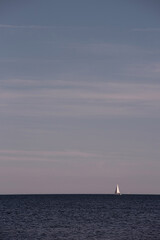 Fototapeta premium A sailboat heading out to sea on a beautiful summer day