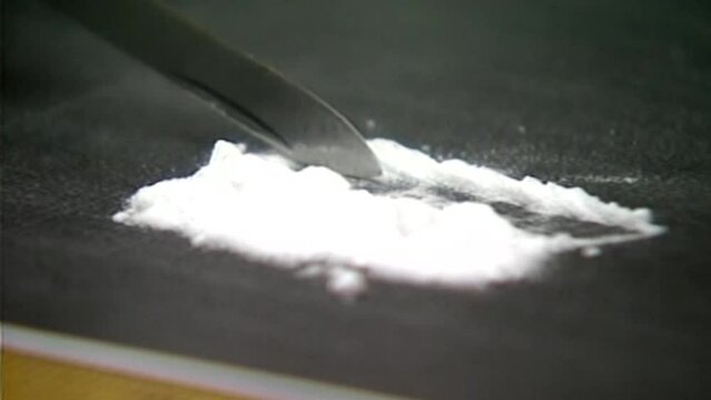 1990S CUTTING UP COCAINE POWDER WITH A POCKET KNIFE