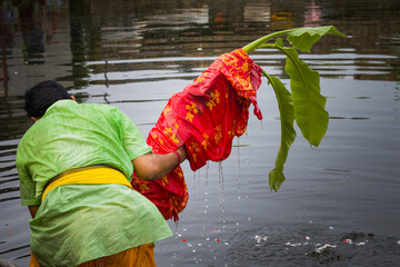 Durga puja ritual of bathing the banana plant. This rite is called kolabou snan in Bengali. The Hindu priest dips the green leaves in water of river or pond. This is beginning of festival.