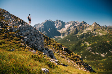 Young hiker on the top og the Rock, High Tatras in the backdrop.