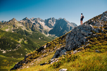 A youthful explorer immerses in the pristine landscapes of the Belianske Tatras, with the iconic High Tatras gracing the horizon in the distance