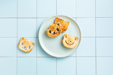 Toasts with chocolate paste in the form of a panda. Children's snack. Top view. Tile background.