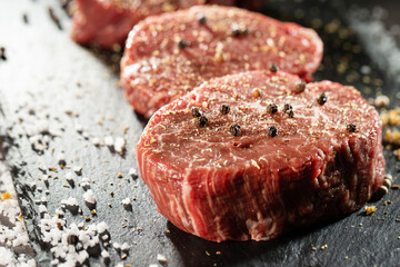 Season raw meat with salt and pepper for steak.
