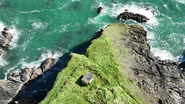 Drone Coast of Ireland Looking down static shot of old WW2 observation post on sea cliffs at The Copper Coast Waterford on a summer day