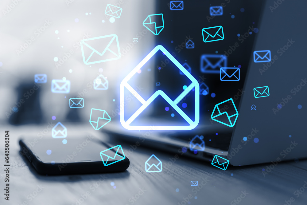 Poster close up of laptop and cellphone on desk with glowing email letter icons on blurry background. commu