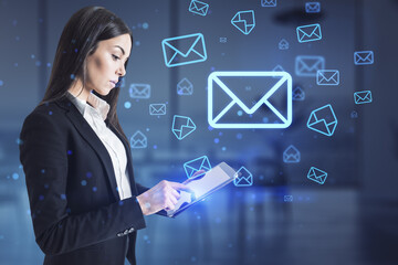 Attractive europeaqn businesswoman using mobile phone with glowing email letter icons on blurry office interior background. Communication and business message concept.