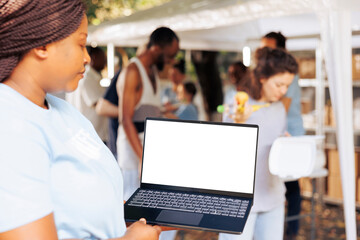 Close-up image showcasing african american female charity worker handling a laptop with blank...