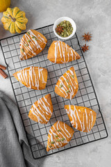Traditional pumpkin scones with cinnamon, anise and sugar glaze on top. Autumn dessert.
