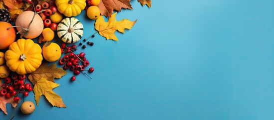 Thanksgiving scene with fall foliage pumpkins and berries against a blue backdrop - obrazy, fototapety, plakaty