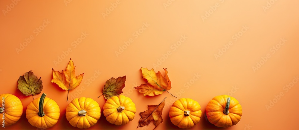 Poster top view of little orange pumpkins on a colored table background fall halloween and thanksgiving the
