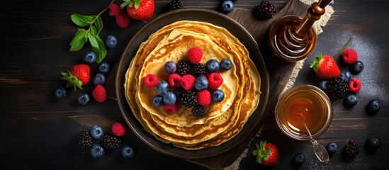 Fototapeta premium Fruity pancakes with honey on a dark background
