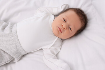 Fototapeta na wymiar Cute newborn baby lying on white soft bed