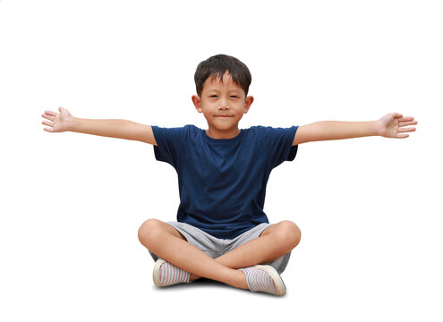 Asian little boy age about 6 years old sitting and arms outstretched or keeping arms raised isolated on white background. Kid with hands wide open.