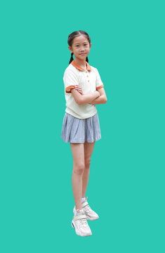 Smart Asian girl child standing and crossing arms isolated on green background. Full length with clipping path.