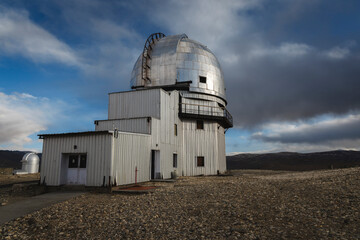 Indian Astronomical Centre in Hanle stands tall against a backdrop of a vivid blue sky adorned with fluffy white clouds.
