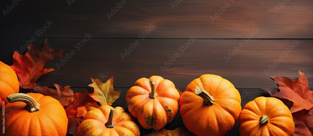 Poster top view of orange pumpkins on a colored table background emblematic of autumn halloween and thanksg