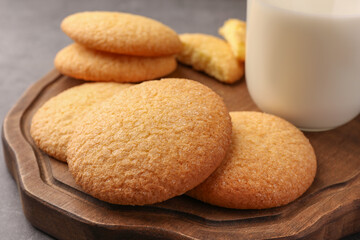 Delicious Danish butter cookies and milk on wooden board, closeup