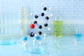 Molecular model and laboratory equipment on light surface