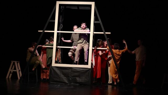 Actors and actresses perform a modern performance on the stage of the theater.	