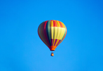 A multicolored hot air balloon on a blue sky background