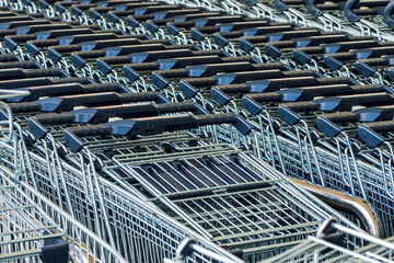 Stacked shopping trolley carts in front of the supermarket store, basket of goods concept