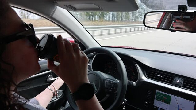 Video, a woman is driving a auto, her hands are on the steering wheel