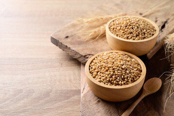 Whole wheat grain in bowl on wooden background, Food ingredients