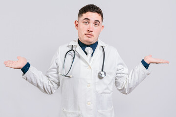 Puzzled doctor with open hands. Doubtful young doctor with open hands isolated. Insecure doctor concept isolated
