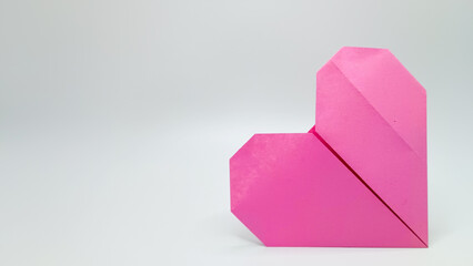 Pink heart origami on a white background
