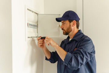 Professional male electrician inspect and repairing electrical systems in houses using a screwdriver