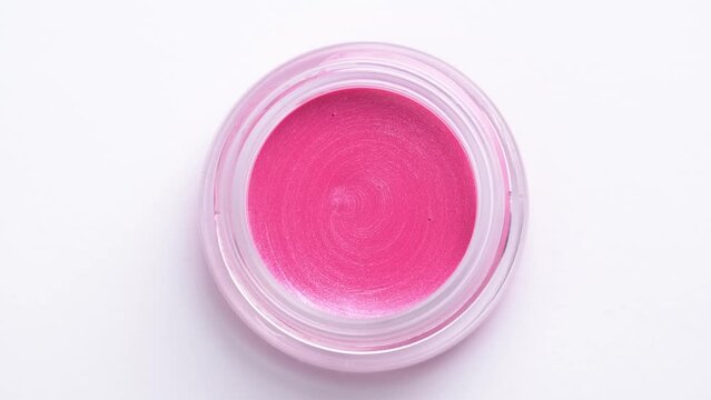 Pink eyeshadow rotating on white background. Advertising cosmetics. Cosmetic liquid lip gloss or blush