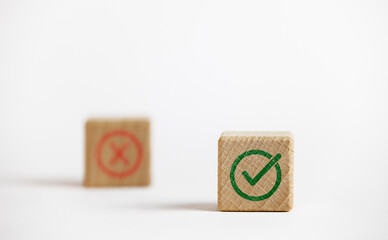 Correct green sign between red cross signs screen printed on wooden blocks to approve and reject business project proposal ideas.