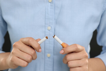 Stop smoking concept. Woman breaking cigarette, closeup