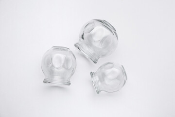 Glass cups on light grey background, flat lay. Cupping therapy