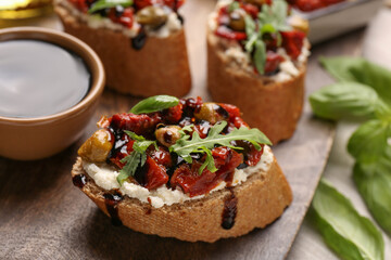 Delicious bruschettas with balsamic vinegar and toppings on table, closeup