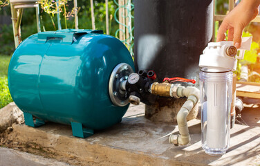 Filtration of water from a well with a sand and dirt filter. Water supply in the country.
