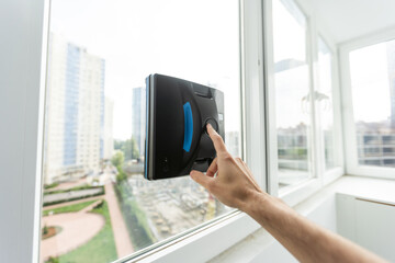 The white robotic window cleaner uses a brush and vacuum for a thorough cleaning. The automatic...