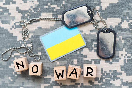 Military ID tags and patch on pixel Ukrainian camouflage, closeup no war